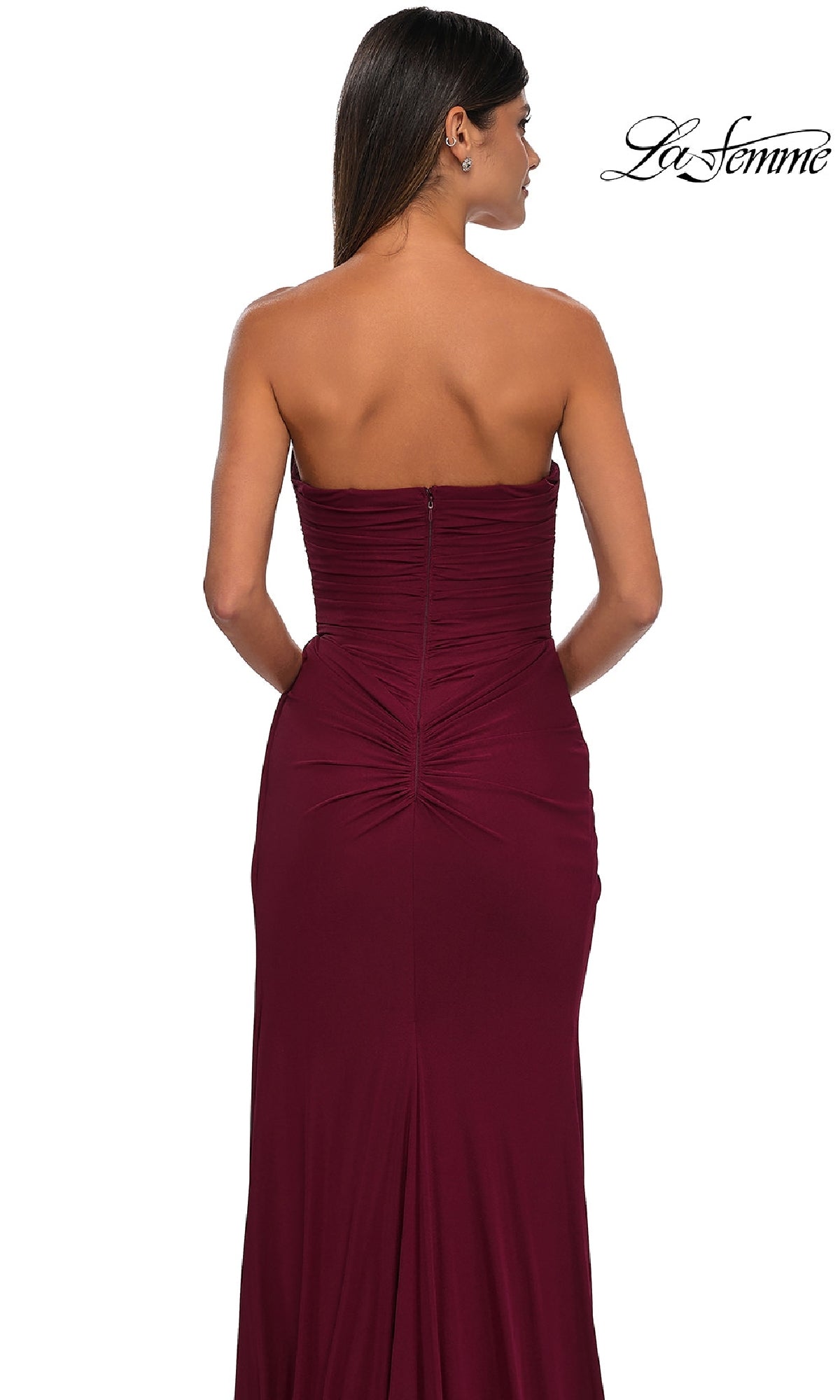 A woman models the Classic Strapless Long Prom Dress: La Femme 33116 in burgundy, shown from the back on a white background with the